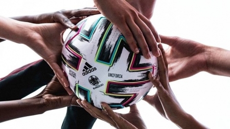Balon de fútbol sujetado por varias manos (ADIDAS) 