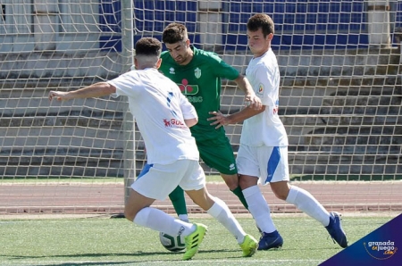 Marcos Toro entre dos jugadores del Guadix en el encuentro de ida (J. M. BALDOMERO)