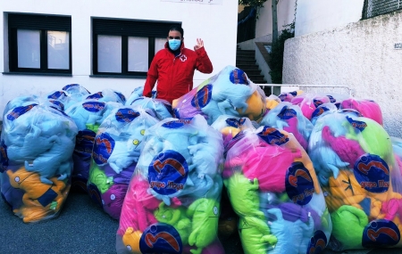 Un trabajador de Cruz Roja, rodeado de los peluches solidarios del Granada CF (CRUZ ROJA GRANADA)