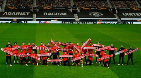 La plantilla del Granada, con las bufandas de las peñas rojiblancas sobre el césped de `Old Trafford` (GCF)