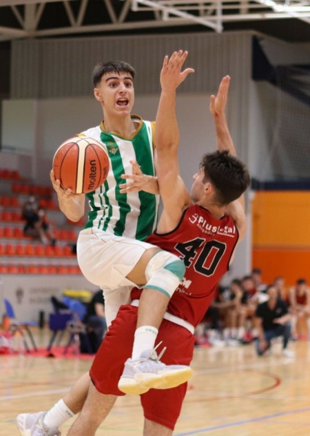 Un jugador del Real Betis penetra ante un jugador de Torrelodones (AYTO. GRANADA)
