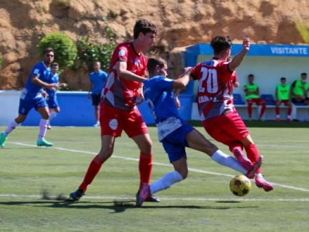 Fabio y Brian pugnan por el balón con un jugador del Monachil (ENCARNI QUESADA)
