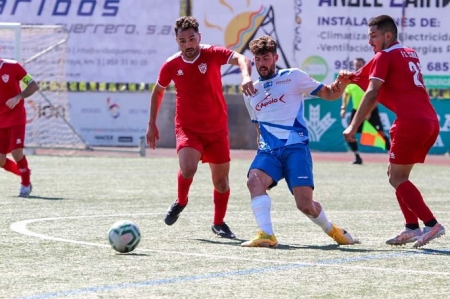 Un jugador del Loja pelea por el balón con dos jugadores del Cubillas (ENCARNI QUESADA) 