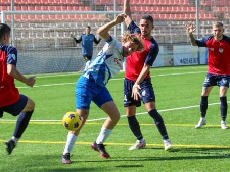 Andrés Macías disputa el balón con dos jugadores del Estepona (ENCARNI QUESADA) 
