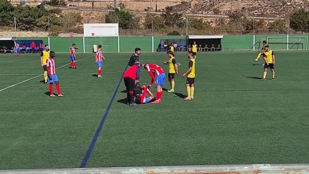 Un jugador del Poli Almería es atendido sobre el césped (POLI ALMERÍA) 