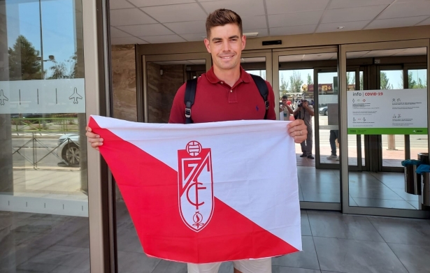 Raúl Fernández posa con una bandera del Granada a su llegada al aeropuerto (FRAN CALVO)