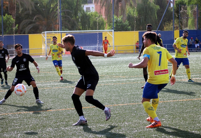 Acción del partido con Esteban Ruiz y dos jugadores malagueños (FRANCISCO CASTILLO)