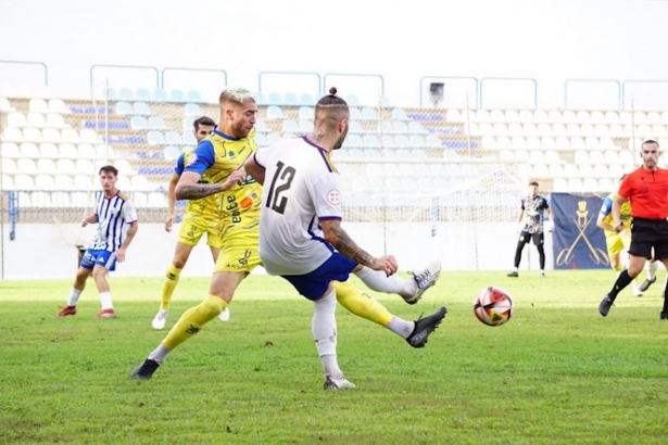 Migue Cobo da un pase durante el derbi (CF MOTRIL)