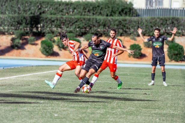 Rober Prieto entre dos jugadores del Almería B (UD ALMERÍA)