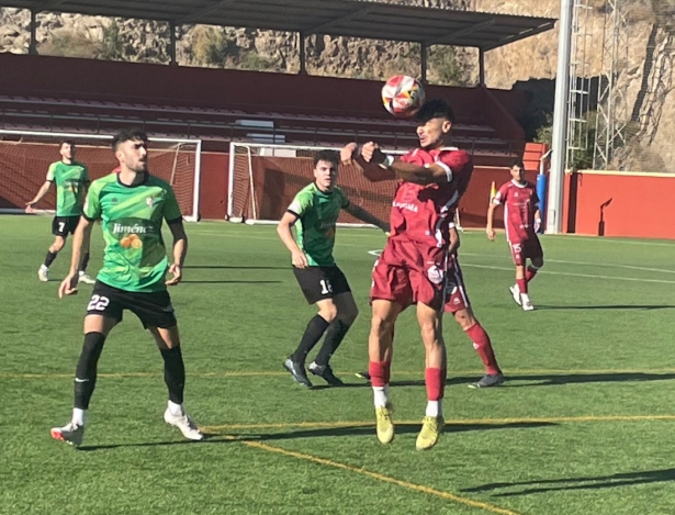 Un jugador del Rincón cabecea ante la mirada de Dani Salvatierra (CD RINCÓN)