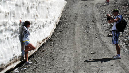 Unos turistas se fotografían junto a una pared de nieve que aún se conserva en Sierra Nevada