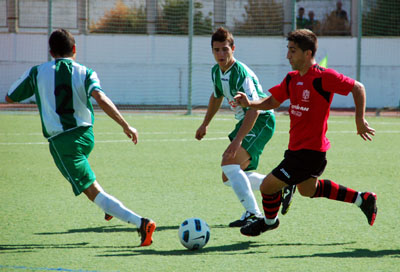 Jugador del Cúllar rodeado por dos jugadores atarfeño (BENJAMÍN MORALES)
