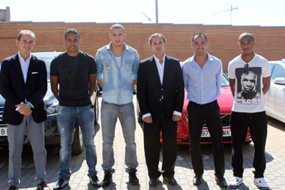 Varios jugadores del Granada posan junto a los coches cedidos por Digasa