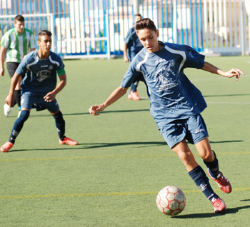 Un jugador cadete controla el balón 