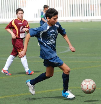 Un jugador infantil conduce el balón 
