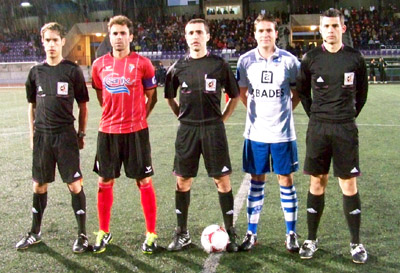El trío arbitral y los capitanes de ambos equipos antes del inicio del encuentro