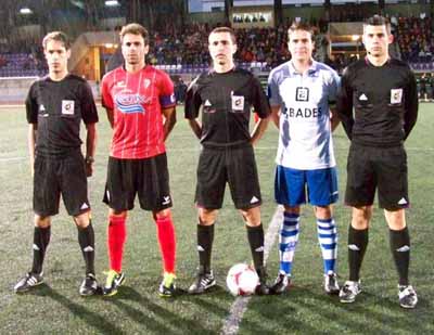 El trío arbitral junto a los capitanes 