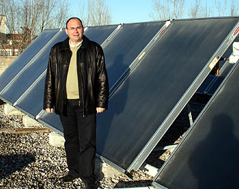 El diputado Pedro Jiménez junto a los colectores solares térmicos