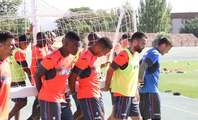 Los jugadores transportan una portería durante un entrenamiento 