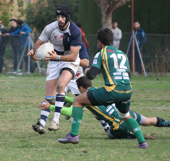 Un jugador del Uni intenta sortear a varios rivales