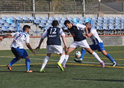 Dos jugadores de cada equipo luchan por la posesión del balón 