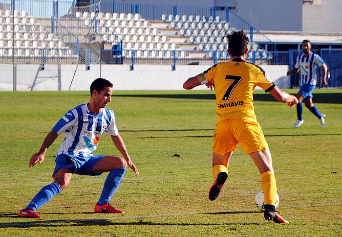 Juanjo Peña, jugador del CF Motril, presiona a Mula (MUCHO DEPORTE)