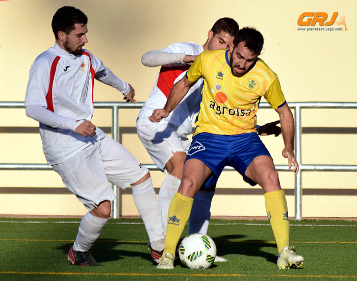 Mario aguanta el balón ante dos jugadores del Martos (CASTILLO)