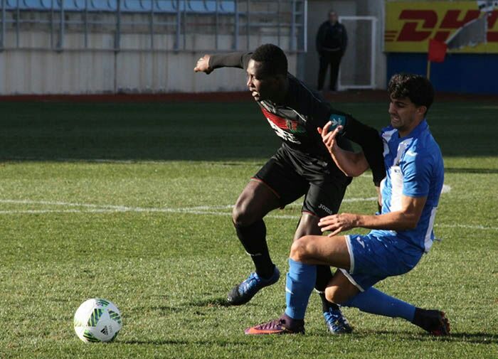 Un jugador del Granada intenta zafarse de un defensor local (LA OPINIÓN DE MURCIA)