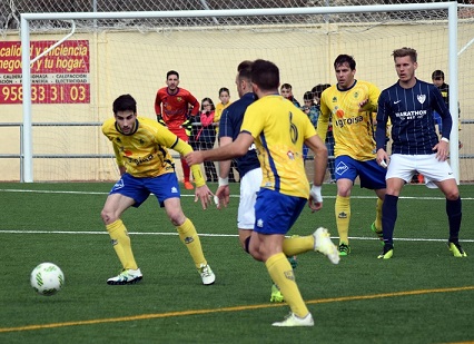 Alberto Heras pugna el balón ante un rival malagueño