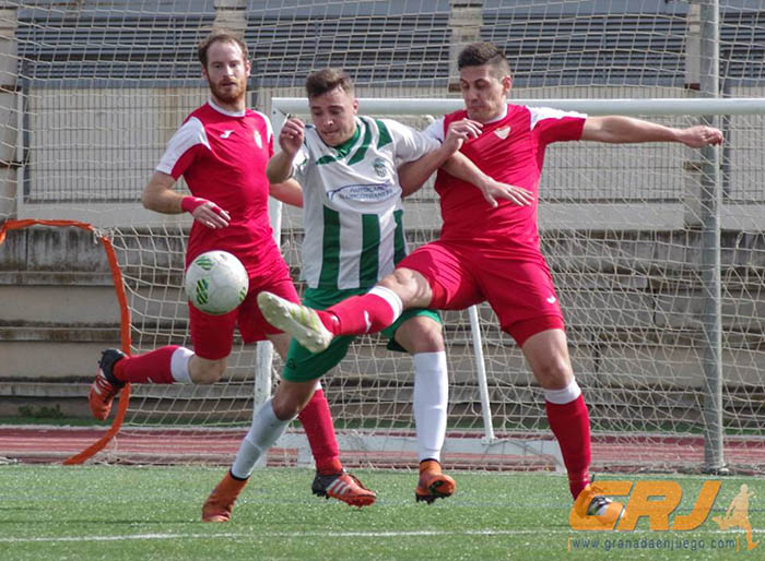 Roland entre dos jugadores del Martos CD (VICENTE CARVAJAL)