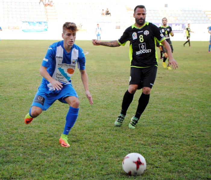 Raúl García (CF Motril) y Apoño (El Palo) miran el esférico (MUCHO DEPORTE)