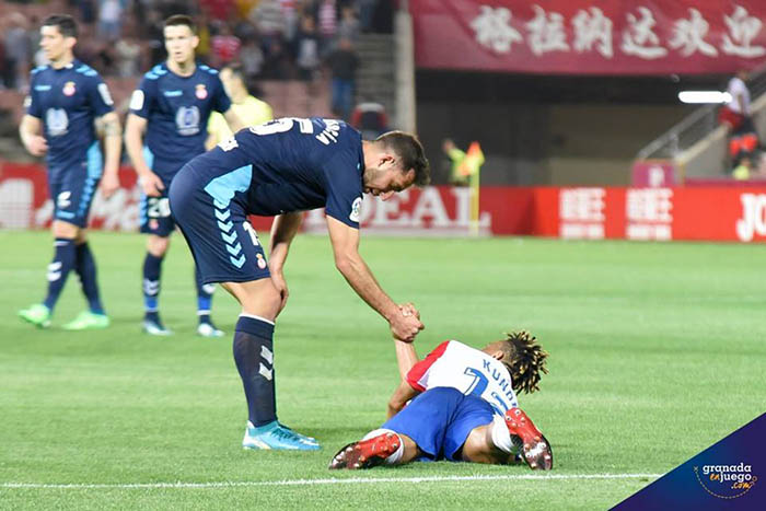 Un jugador visitante ayuda a levantarse a Kunde al final del encuentro (JOSÉ M. BALDOMERO)