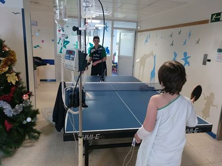 Un jugador de Vegas del Genil T.M. juega con un niño de la planta de Oncología (AYTO. VEGAS DEL GENIL) 