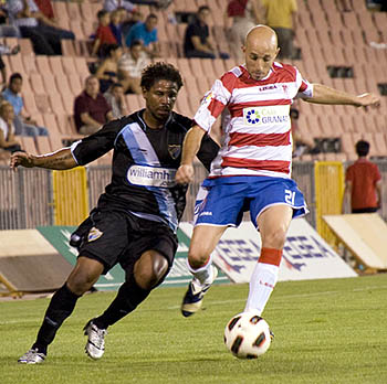 Óscar Pérez encimado por un jugador del Málaga CF (BALDOMERO)