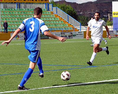 Paquito Sánchez, jugador del Guadix CF, presiona a un futbolista del CD Vera