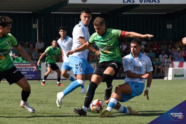 David Hurtado entre dos jugadores del Atlético Malagueño (JOSÉ M. BALDOMERO)