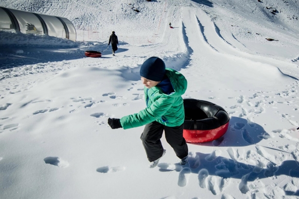 Un niño se dispone a lanzarse con un flotador en la zona de Borreguiles de la Estación de Sierra Nevada, en una imagen de archivo (SIERRA NEVADA)