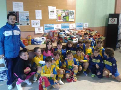 Algunos de los participantes posan junto a los alimentos entregados 